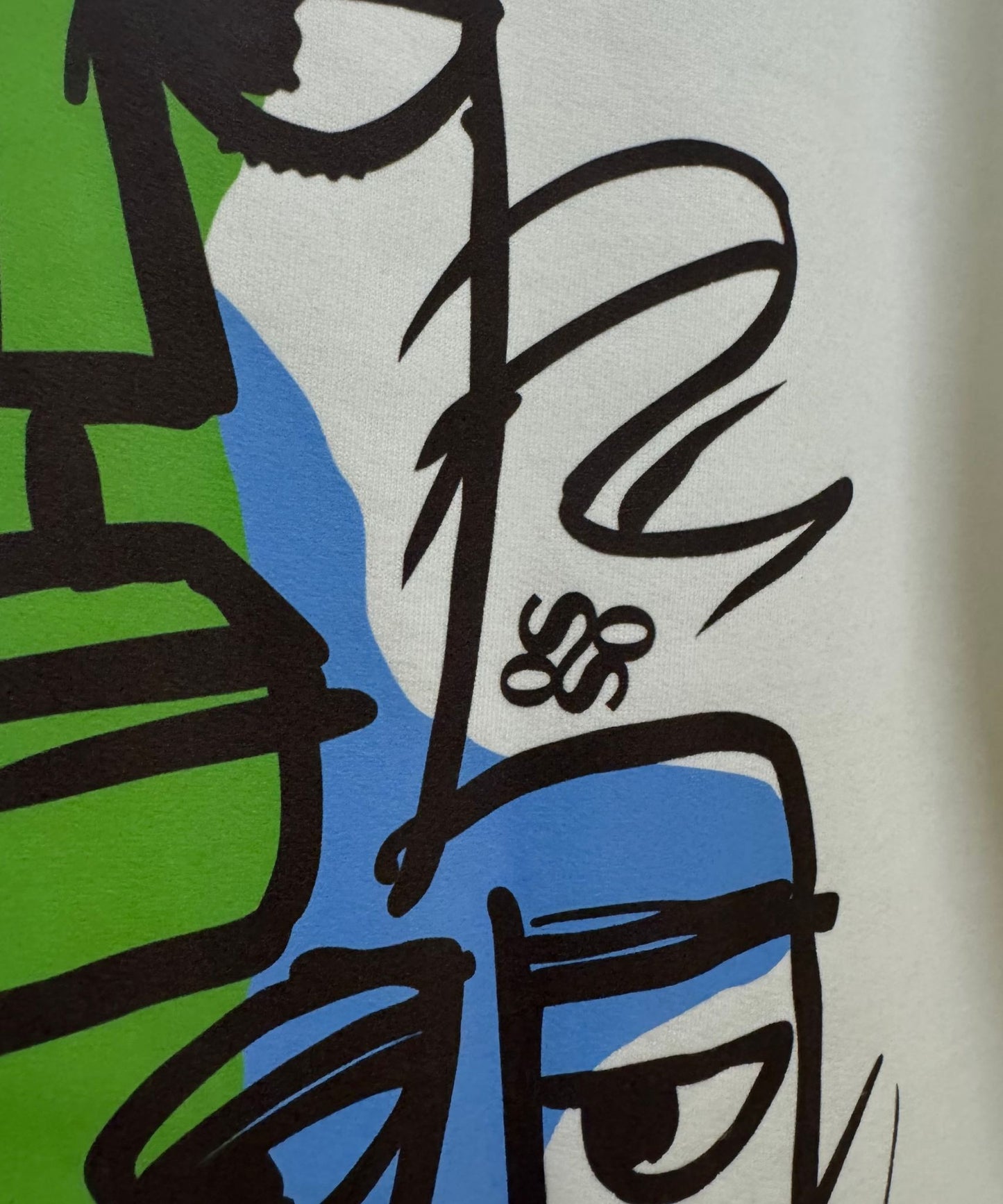 Detailed view of blue and green abstract splashes and graffiti-style line art – Sense of Street original design.
