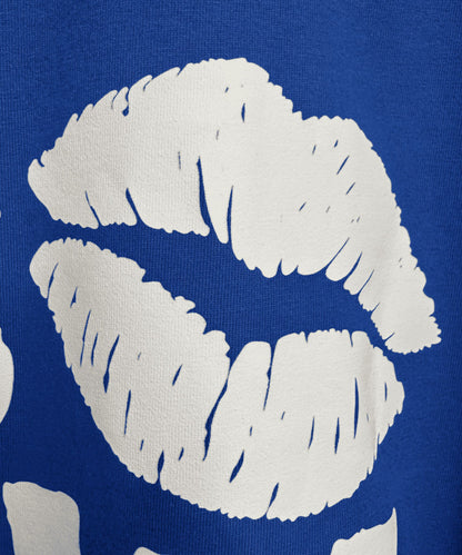 Detailed view of Kiss Now Chaos Later premium screen print on blue fabric - Sense of Street.