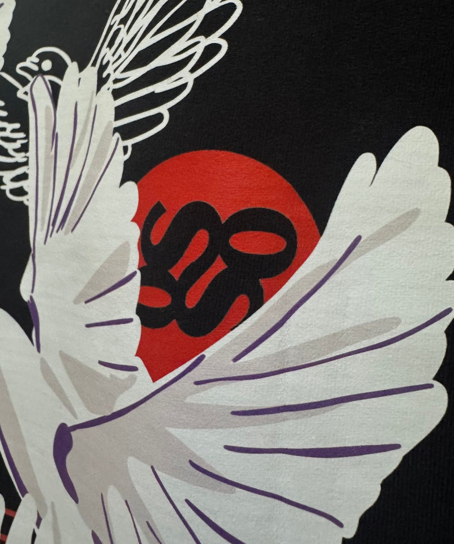 Detailed view of the bird mural and SOS emblem on the back of Love and Peace streetwear t-shirt.